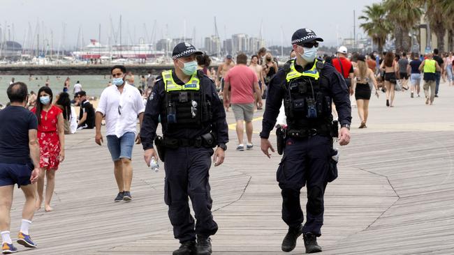 Police patrol a crowded St Kilda beach. Picture: NCA NewsWire / David Geraghty