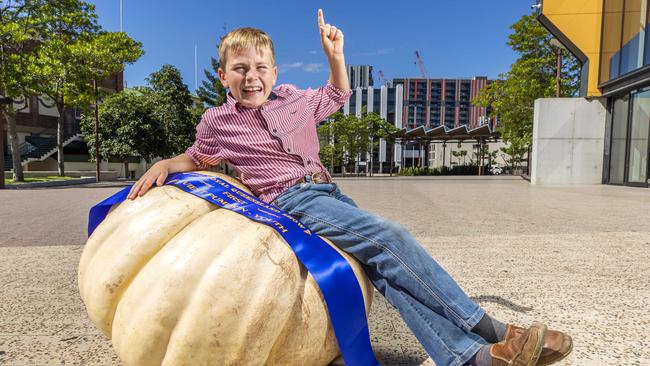 Eight-year-old Jimmy Finch sits on his mega pumpkin. Picture: Richard Walker