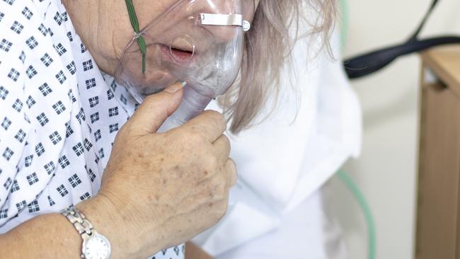 Woman in hospital using a respirator.