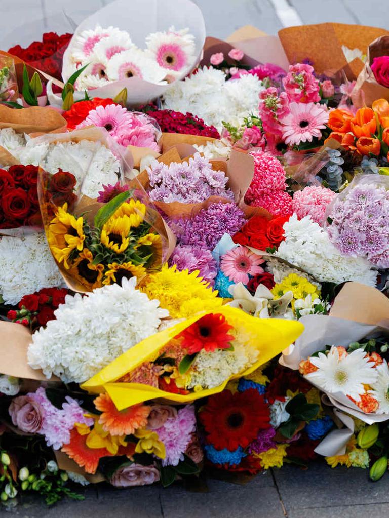 SYDNEY, AUSTRALIA - NewsWire Photos APRIL 14, 2024: Floral tributes at Bondi Junction today after 6 people were killed in a massacre at Bondi Westfield yesterday afternoon. Allegra Weeden and Ella Finlay lay flowers. Picture: NCA NewsWire / David Swift