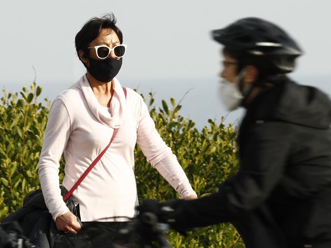 MELBOURNE, AUSTRALIA - JULY 25: A woman, wearing a face mask, walks along St Kilda on July 25, 2020 in Melbourne, Australia. Victoria reported seven COVID-19 deaths on July 24, the state's highest toll since the start of the pandemic. Effective, July 23, face coverings are mandatory for people leaving their homes in the Melbourne metropolitan area or the Mitchell Shire with anyone failing to do so subject to a $200 fine. Metropolitan Melbourne and the Mitchell shire remain in lockdown due to the rise in COVID-19 cases through community transmissions, with people permitted to leave home only for exercise, work, to buy essential items, or to access childcare and healthcare. Lockdown measures are in place until August 19. (Photo by Darrian Traynor/Getty Images)