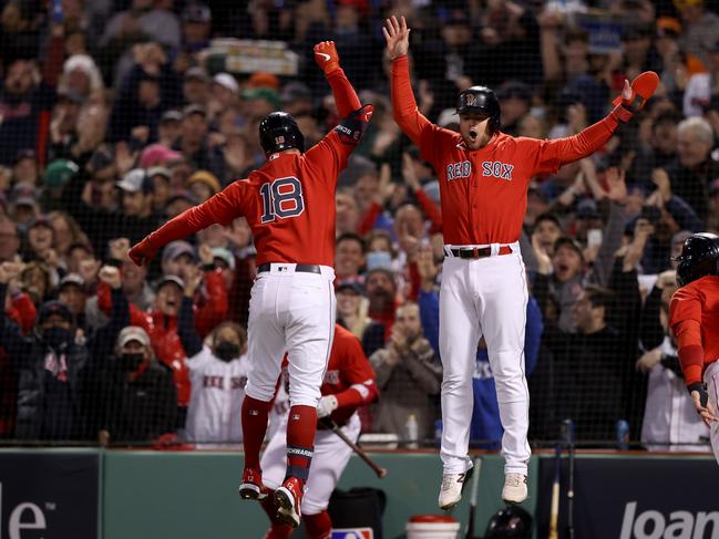 BOSTON, MASSACHUSETTS - OCTOBER 18: Kyle Schwarber #18 of the Boston Red Sox celebrates with Christian Arroyo #39 after Schwarber hit a grand slam home run against the Houston Astros in the second inning of Game Three of the American League Championship Series at Fenway Park on October 18, 2021 in Boston, Massachusetts. (Photo by Elsa/Getty Images)