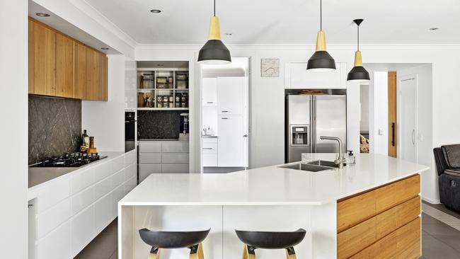 Feature timber panelling and pendant lighting are features of the kitchen.