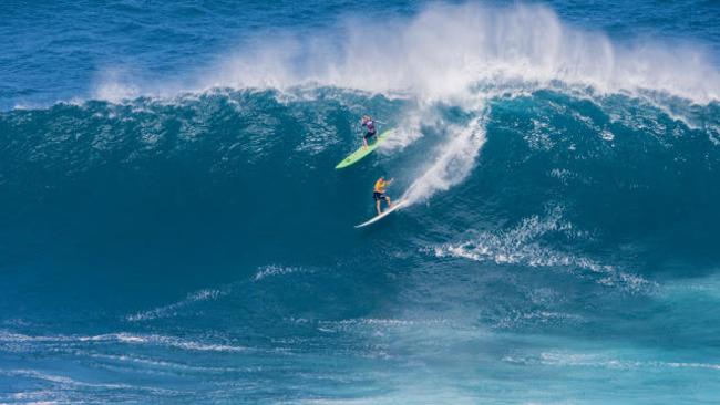 Felicity Palmateer (yellow) tackles the big waves at Jaws.