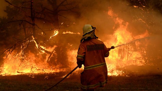 A firefighter tried to keep the flames at bay during the height of the blazes. Picture: Jeremy Piper