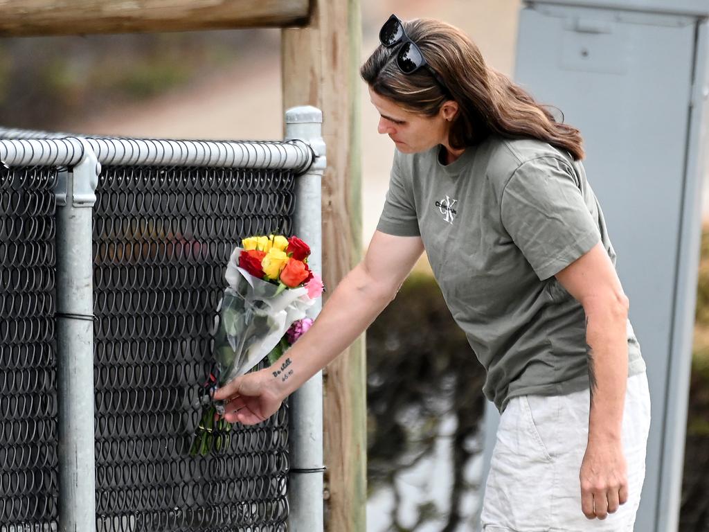 A woman laying flowers in a tribute to the grandmother who was killed in Murrumba Downs. Picture, John Gass