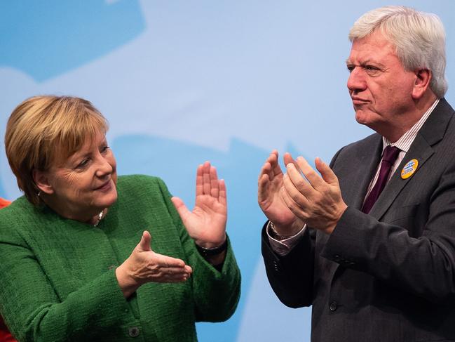 (FILES) In this file photo taken on October 25, 2018 German Chancellor Angela Merkel (L) and Hesse's State Premier amd Deputy Chairman of the Christian Democratic Union (CDU) Volker Bouffier applaud on stage during an election rally in Fulda, western Germany ahead of the on October 28th regional election. (Photo by Silas Stein / dpa / AFP) / Germany OUT