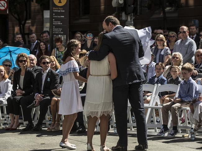 Siege victim Katrina Dawson's daughter Chloe hugs her father Paul Smith during the unveiling of a permanent memorial honouring the lives of Tori Johnson and Katrina Dawson. Picture: Jessica Hromas/Getty Images