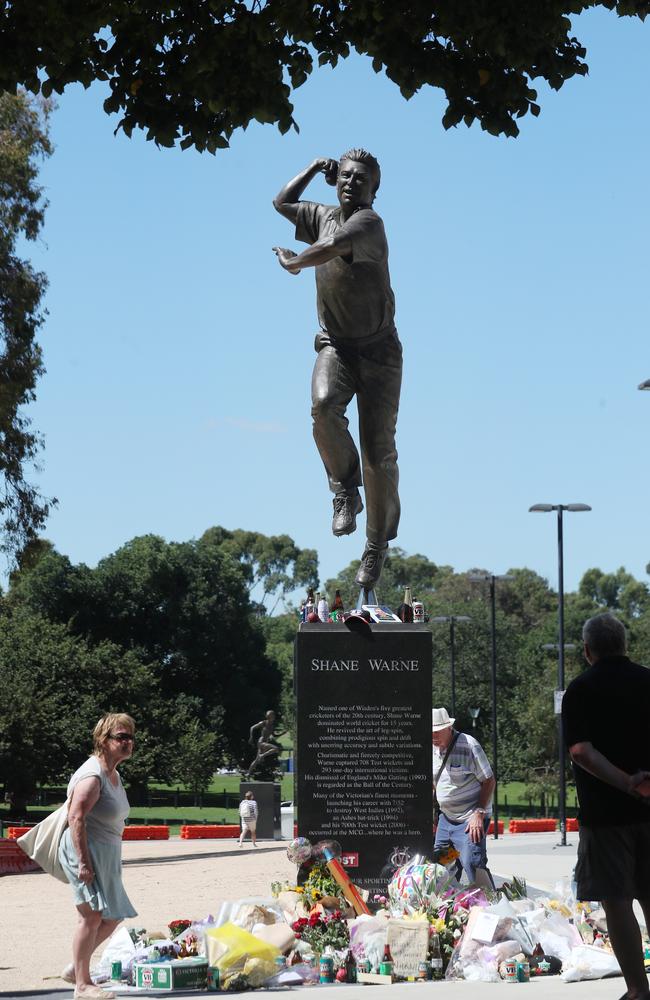 People continue to place flowers and other items at the Shane Warne statue at the MCG days after his death in Thailand. Picture: NCA NewsWire / David Crosling.