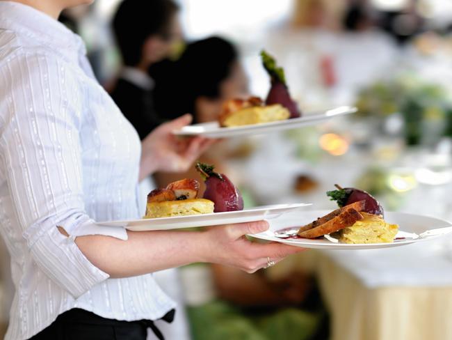 Waitress carrying three plates with meat dishGeneric photo of woman working in hospitality industry