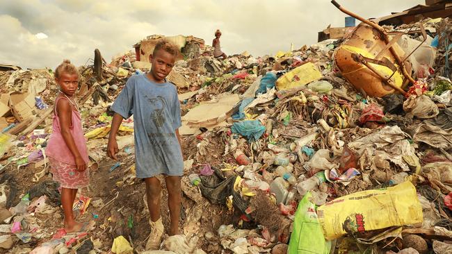 Children scavenge among the rubbish for valuables near their homes on Honiara’s city dump. Picture: Vanessa Hunter