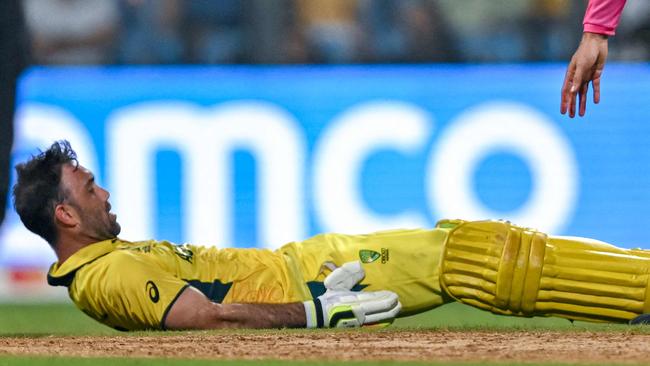 Australia's Glenn Maxwell (bottom) falls on the ground after a muscle cramp during the 2023 ICC Men's Cricket World Cup one-day international (ODI) match between Australia and Afghanistan at the Wankhede Stadium in Mumbai on November 7, 2023. (Photo by INDRANIL MUKHERJEE / AFP) / -- IMAGE RESTRICTED TO EDITORIAL USE - STRICTLY NO COMMERCIAL USE --