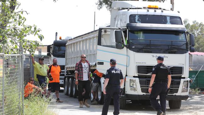 Black Swan Lake protest at Bundall goes to another level, with protesters chaining themselves to the fence and then getting themselves arrested after running onto the worksite and stopping the trucks. Police inform workmen of the situation. Picture Glenn Hampson
