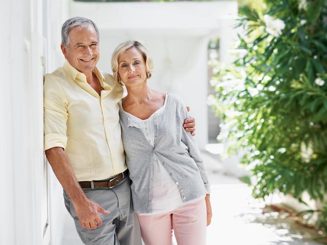 Portrait of an older couple posing for the camera in front of their house with copy space; Senior homeowner couples at home, mortgage, generic