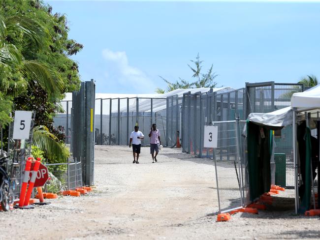 Daily Telegraph. Nauru Day 4.  2018 Pacific Islands Forum Nauru. Refugee men walk near the entry gate of detention camp 2 which houses single men.  Pic Nathan Edwards