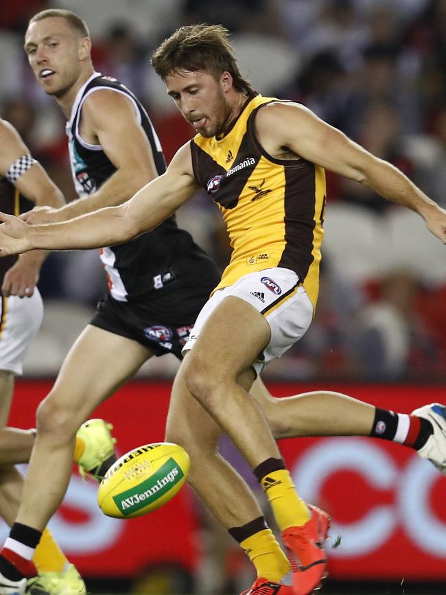 Tom Phillips gets a kick away for Hawthorn.