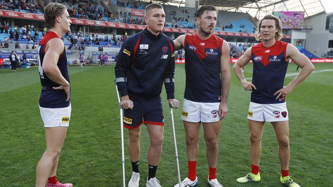 Tomlinson with teammates Trent Rivers (left), Michael Hibberd and Ed Langdon. Picture: Dylan Burns/AFL Photos via Getty Images