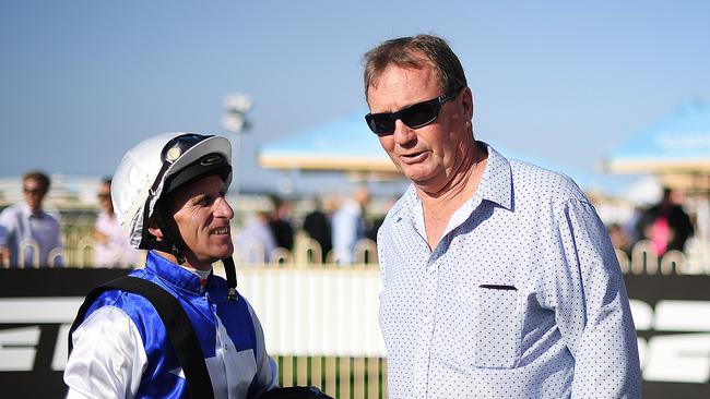 Jockey Dale Smith speaks to trainer Gary Duncan after riding Tversky to victory in race 7 at Doomben Racecourse in Brisbane, Saturday, August 4, 2018. (AAP Image/Albert Perez)