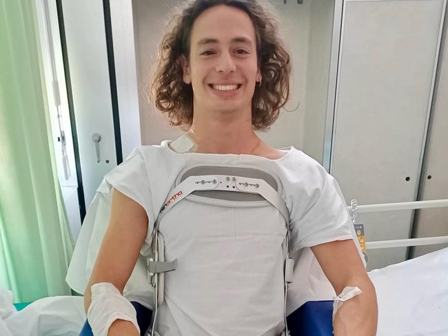 Grinning through the pain: Hobart motor racer Alex Peroni in San Gerardo hospital in Italy.