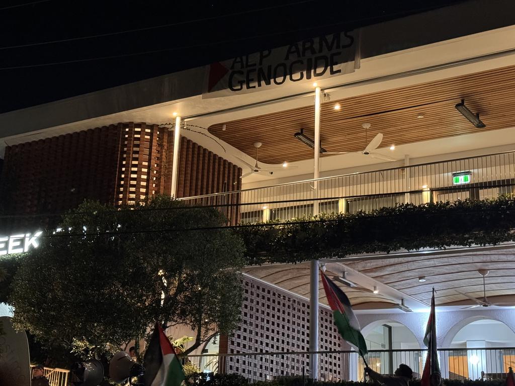 A protester scaled the building to hang a banner. Picture: Mikaela Mulveney