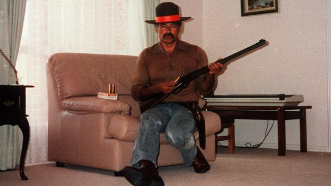 Ivan Milat, convicted of the murders of seven backpackers, poses in his lounge room with firearms.