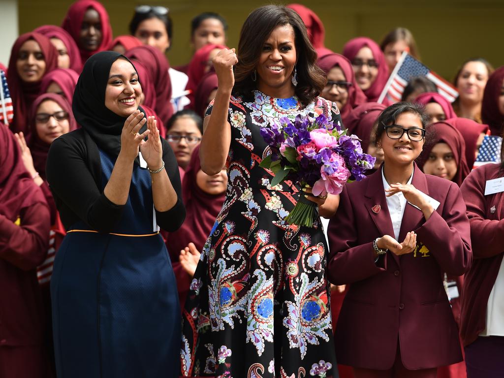 US First Lady Michelle Obama gestures and holds flowers as she is received by young students holding the American flag in the courtyard before an event as part of the ‘Let Girls Learn Initiative’ at the Mulberry School for Girls on June 16, 2015 in London, England. Picture: Getty