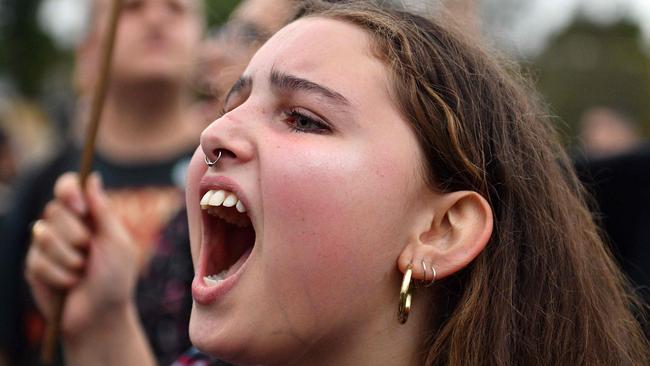 A protester shouts agaisnt racism before right-wing British provocateur Milo Yiannopoulos is set to speak to supporters in Sydney on December 5, 2017.  Right-wing British provocateur Milo Yiannopoulos blasted those who do not agree with him as "petulant babies" on December 5 after violent protests in Australia. / AFP PHOTO / Saeed KHAN