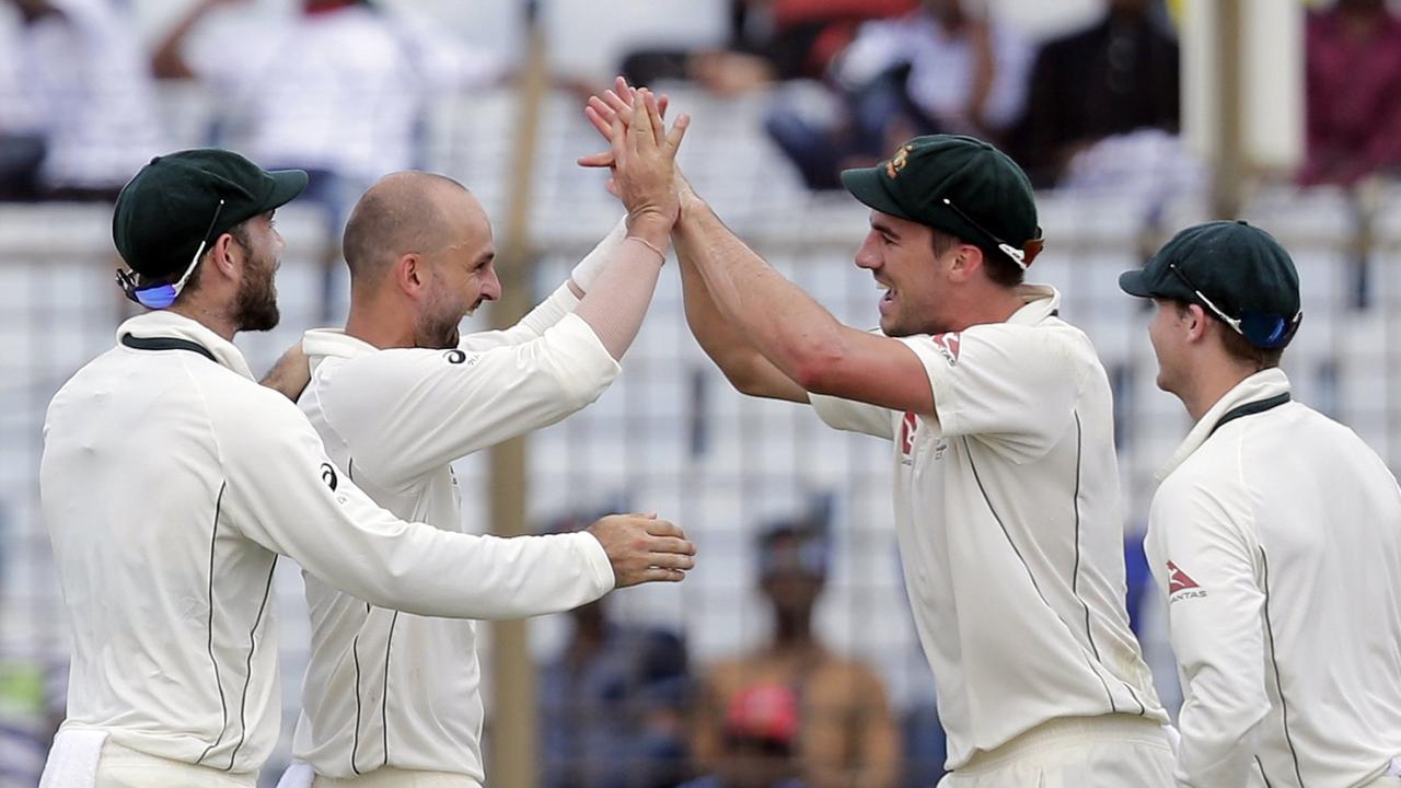 Maxwell (left) celebrates a wicket with Pat Cummins and Nathan Lyon.