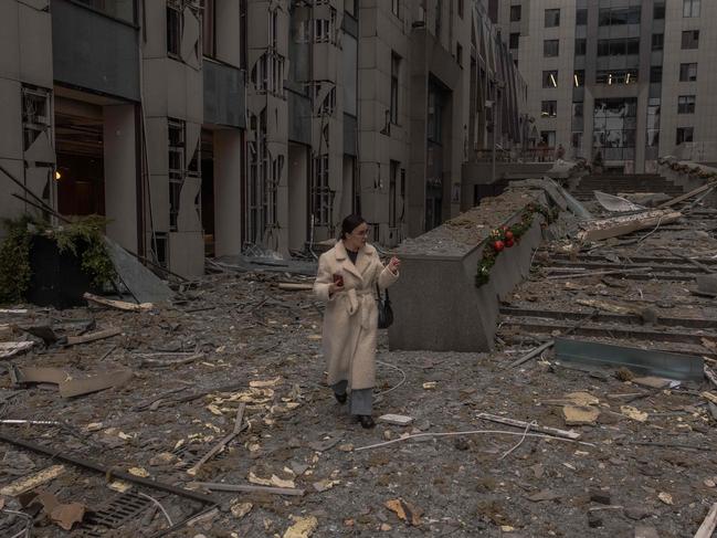 TOPSHOT - A woman walks among rubbles at the site of a missile attack in Kyiv on December 20, 2024, amid the Russian invasion of Ukraine. Russian missiles targeted the Ukrainian capital Kyiv at sunrise on December 20, 2024, killing at least one person and cutting heating to hundreds of residential buildings in cold temperatures. (Photo by Roman PILIPEY / AFP)