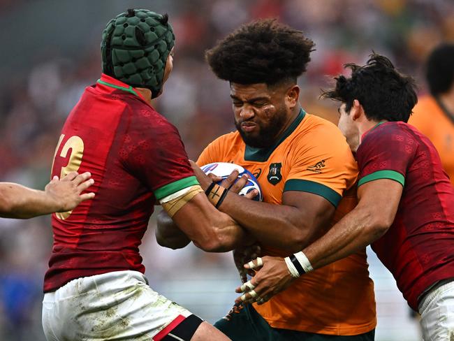 TOPSHOT - Australia's number eight Rob Valetini (C) is tackled by Portugal's outside centre Pedro Bettencourt (L) and Portugal's inside centre Tomas Appleton (R)  during the France 2023 Rugby World Cup Pool C match between Australia and Portugal at Stade Geoffroy-Guichard in Saint-Etienne, south-eastern France, on October 1, 2023. (Photo by Olivier CHASSIGNOLE / AFP)