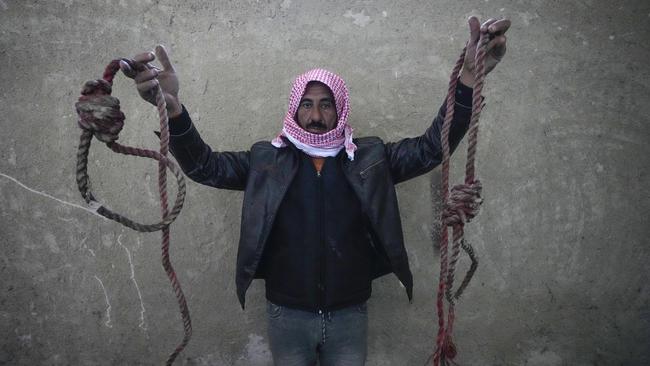 A man holds up ropes tied into nooses, found in Saydnaya prison on Monday. Picture: AFP