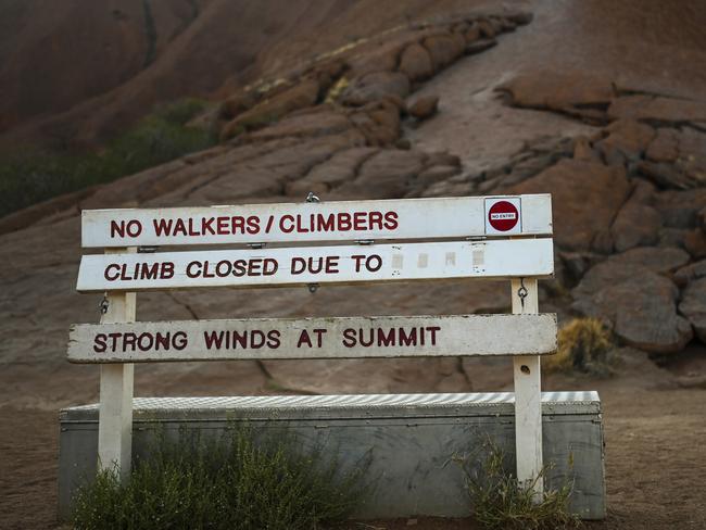 The sign at the bottom of the climb area indicates the climb is closed due to 'strong winds at summit at Uluru, also known as Ayers Rock at Uluru-Kata Tjuta National Park in the Northern Territory on Friday. Picture: AAP