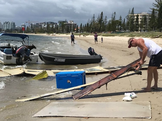 A man helping to remove large parts of the dismantled houseboat. Photo: Emily Halloran