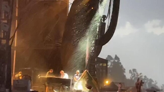 Staff remove Elton John’s piano during torrential rain last Friday.