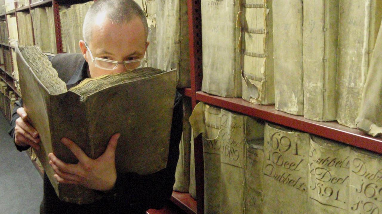 Prof Matija Strlic smells a historical book in the National Archives of the Netherlands. Photograph: Matija Strlic