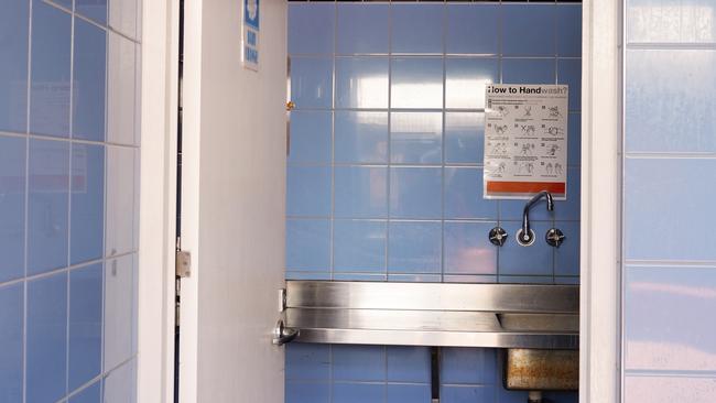 Townsville, Queensland, Australia - December 2020: Inside a blue tiled male public toilet at a rest stop