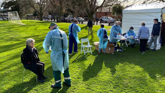 Interstate health workers from Adelaide take swab samples at a COVID-19 testing station in a park in the Melbourne suburb of Brunswick West.