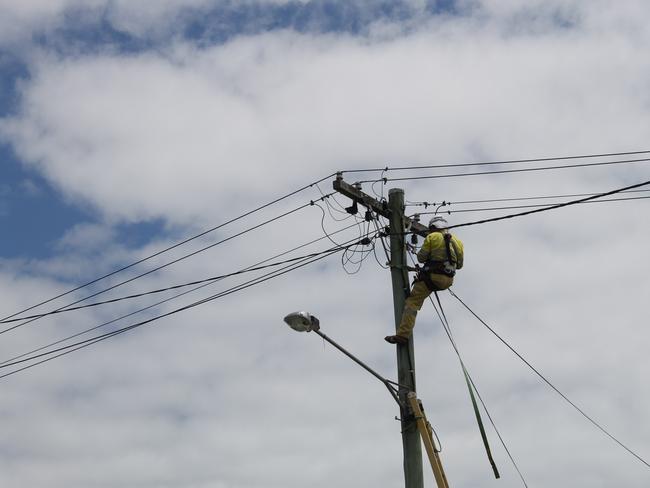 Ergon Energy working on power cables connected to a home on fire in Johnson St, West Mackay.