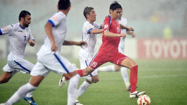 Ri Yong Jik of North Korea (R) takes a shot.