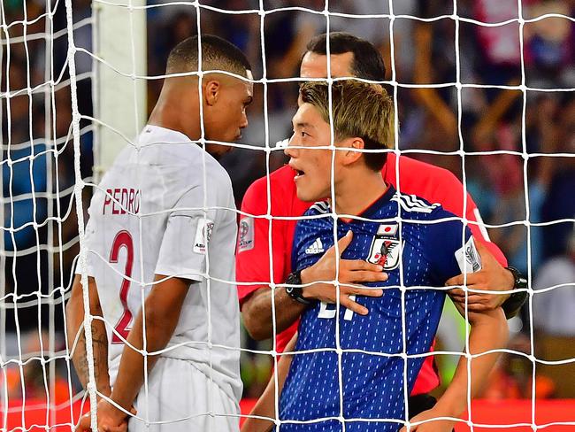 Uzbek referee Ravshan Irmatov (R) separates Qatar's defender Pedro Miguel Correia (L) and Japan's midfielder Ritsu Doan (C). Picture: AFP