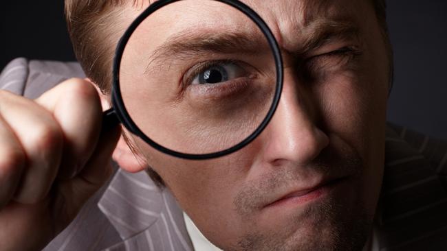 man with magnifying glass in business suit. tax generic businessman