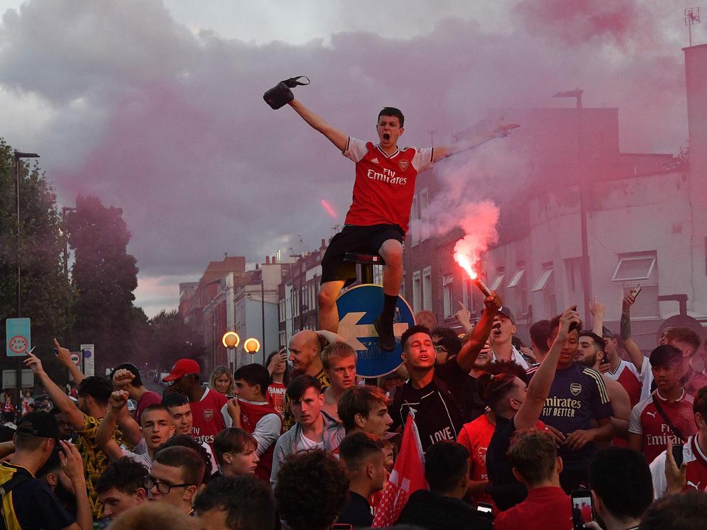 Arsenal fans celebrate outside the Emirates stadium in north London on August 1, 2020, after their team won the English FA Cup final football match against Chelsea. - Arsenal won the match 2-1. (Photo by JUSTIN TALLIS / AFP)