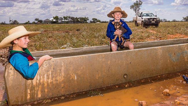 Abbie Hoch, 11, and brother James, 9, often cool off in the lake on their Quilpie property – but a water trough does in a pinch.