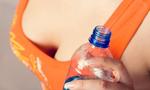 Girl in orange top holding a water bottle.
