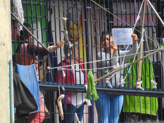 Cassie Sainsbury (centre) beside an inmate holding a sign written in Spanish, which translated means “Cassandra asks freedom immediately”. Picture: Nathan Edwards