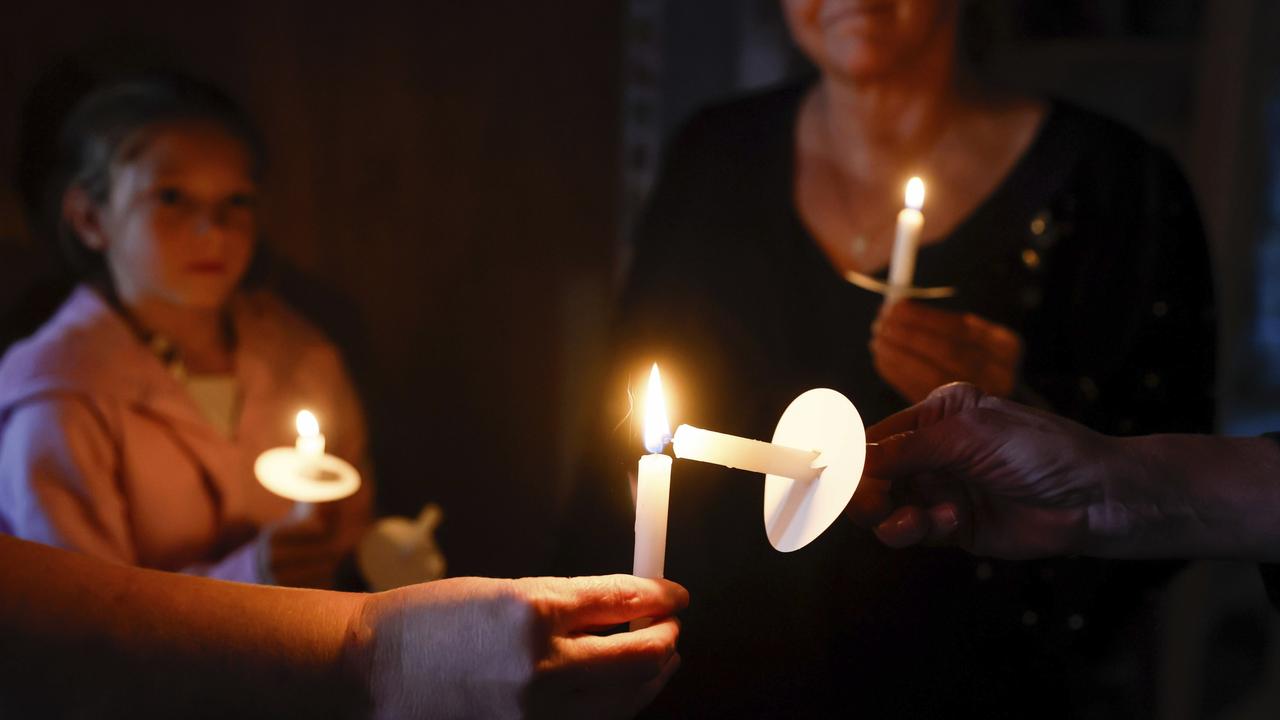 Pastor Carrie Bland uses her candle to light others. Picture: Jennifer Buchanan/The Seattle Times via AP