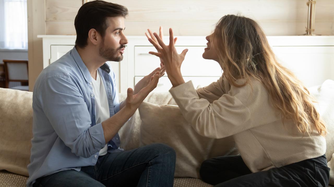 Emotional annoyed stressed couple sitting on couch, arguing at home. Angry irritated nervous woman man shouting at each other, figuring out relations, feeling outraged, relationship problems concept.