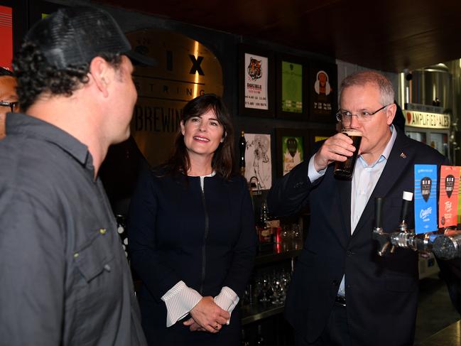 Australian Prime Minister Scott Morrison pours a beer during a visit with Federal MP for Robertson Lucy Wicks (centre) and co-owner Ryan Harris (left) to the Six Strings Brewery in Erina on the NSW Central Coast, Wednesday, October 10, 2018. (AAP Image/Dan Himbrechts) NO ARCHIVING