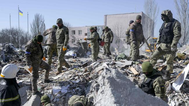 Ukrainian soldiers search for bodies in the debris at the military school hit by Russian rockets in Mykolaiv, southern Ukraine. Picture: Bulent Kilic / AFP