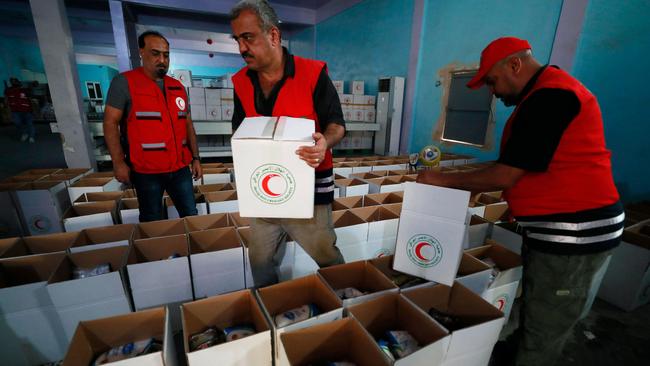 Iraqi Red Cresent Society employees pack humanitarian aid bound for Egypt and then onto the Palestinians of the Gaza Strip, at a warehouse in Baghdad. Picture: AFP